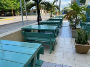 Green dining tables are standing outside near the Pullman in Cuba