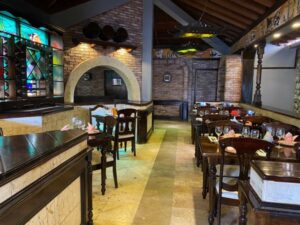 Brown wooden tables are in the restaurant of Pullman Hotel, Cuba